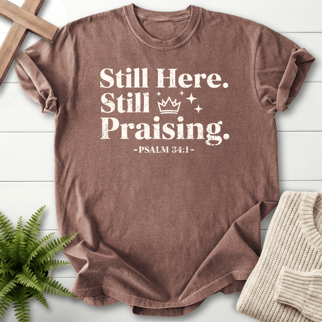 Espresso Christian t-shirt for women with bold distressed Still Here, Still Praising lettering, a crown icon, and Psalm 34:1.