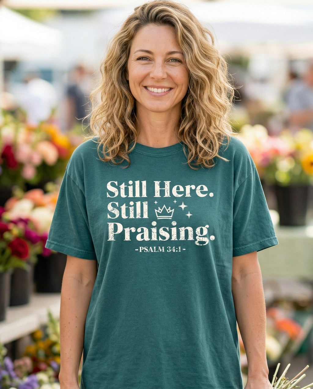 Still Here Still Praising – Blue Spruce women's Christian tee, lifestyle photo in farmers market – Bold grunge-style text reading 'Still Here – Psalm 34:1 – She Wears Faith