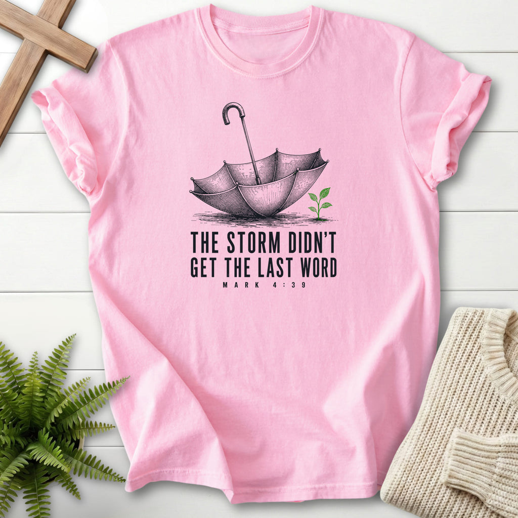 Flatlay of a Blossom Comfort Colors 1717 garment-dyed Christian tee with an engraved umbrella and seedling with "Storm Didn't Get the Last Word T-Shirt".