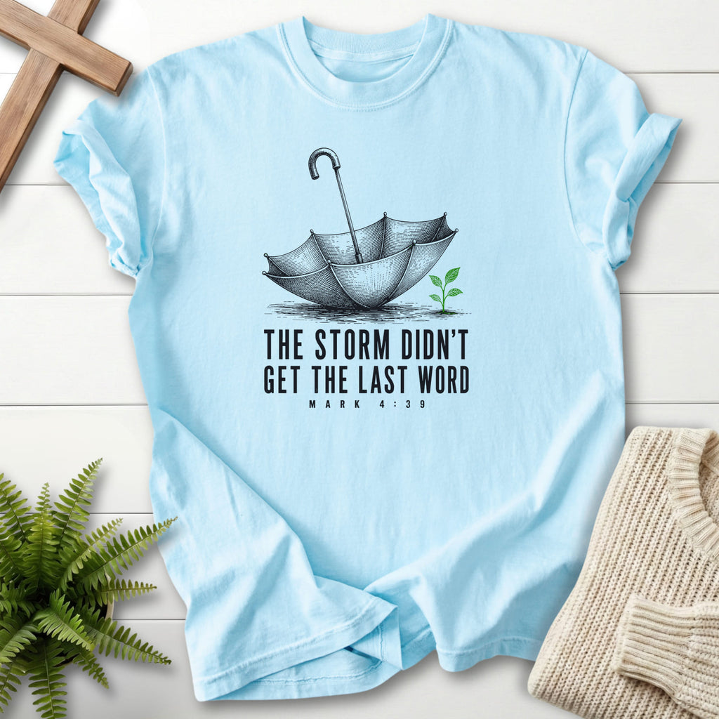 Chambray color option for the Storm Didn't Get the Last Word Christian graphic tee with an engraved umbrella and seedling with "Storm Didn't Get the Last.