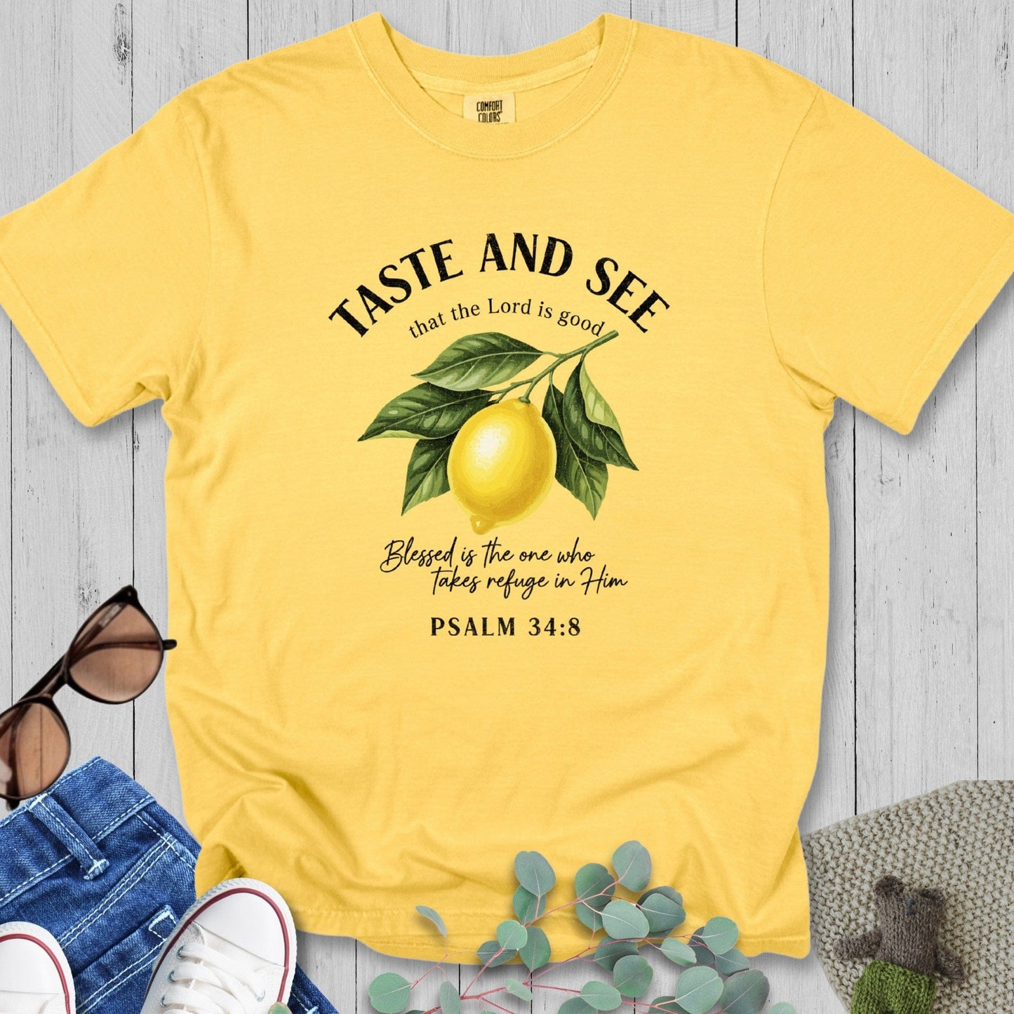 Citrus Yellow Comfort Colors 1717 tshirt displaying a bright lemon illustration and Bible verse. Sunny Christian women tee with the phrase "Blessed is the one who takes refuge in Him," perfect for summer US faith wear.