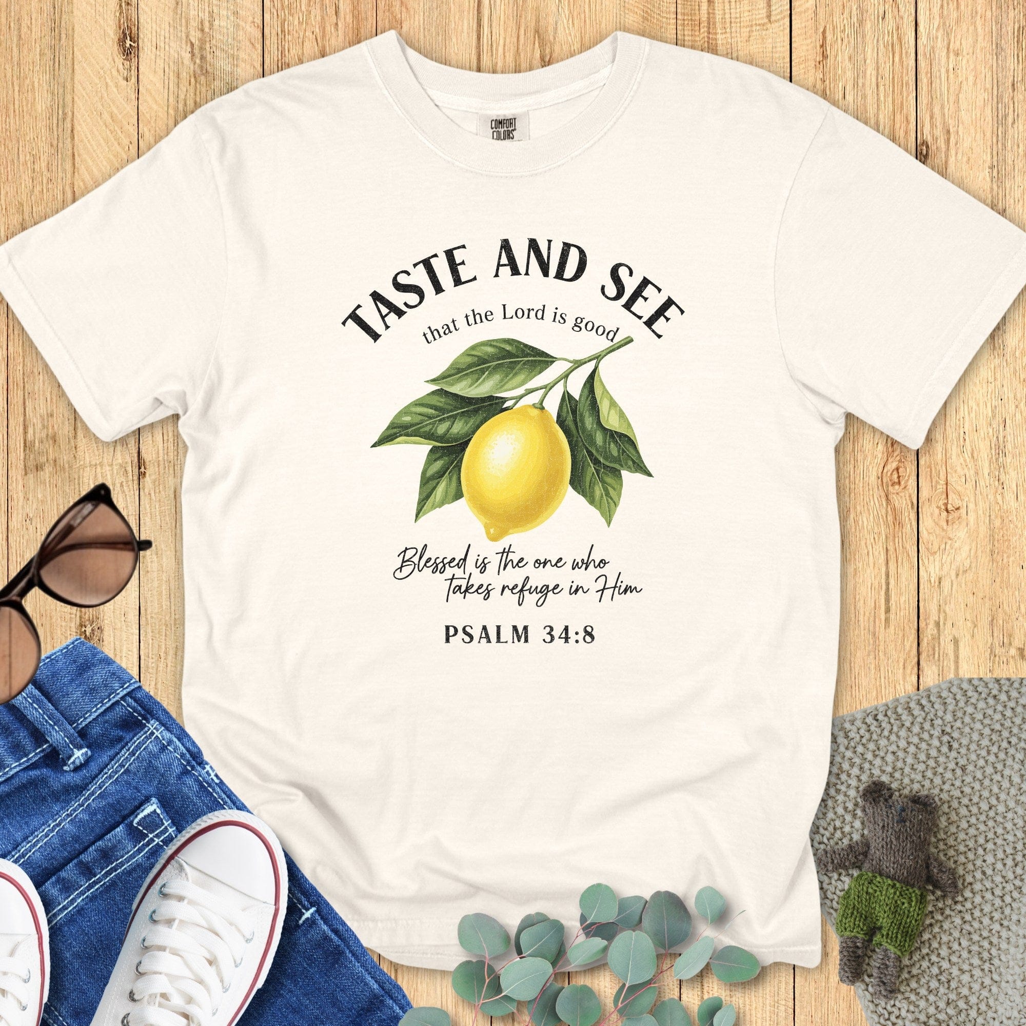 Flat lay of an Ivory Comfort Colors 1717 tshirt featuring a vintage botanical lemon design. A minimalist Christian women tee with "Taste and See that the Lord is good" Psalm 34:8 scripture, styled for US faith wear collections.