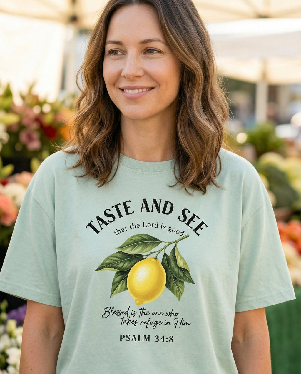 Taste and See Lemon Scripture – Bay women's Christian tee, lifestyle photo in farmers market – Arched 'Taste and See That the Lord Is Good' text above a botanical le – Psalm 34:8 – She Wears Faith