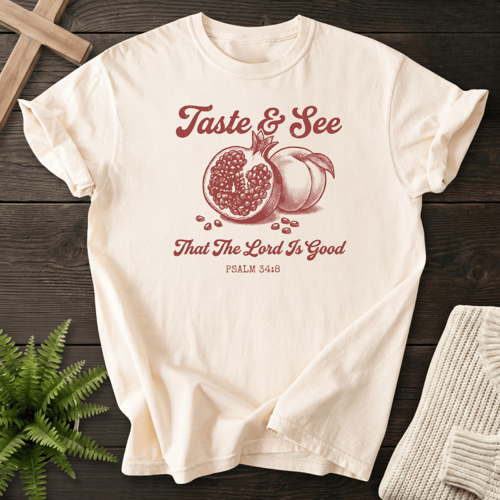Ivory faith-based tee with the Taste and See That the Lord Is Good pomegranate design, inspired by Psalm 34:8.