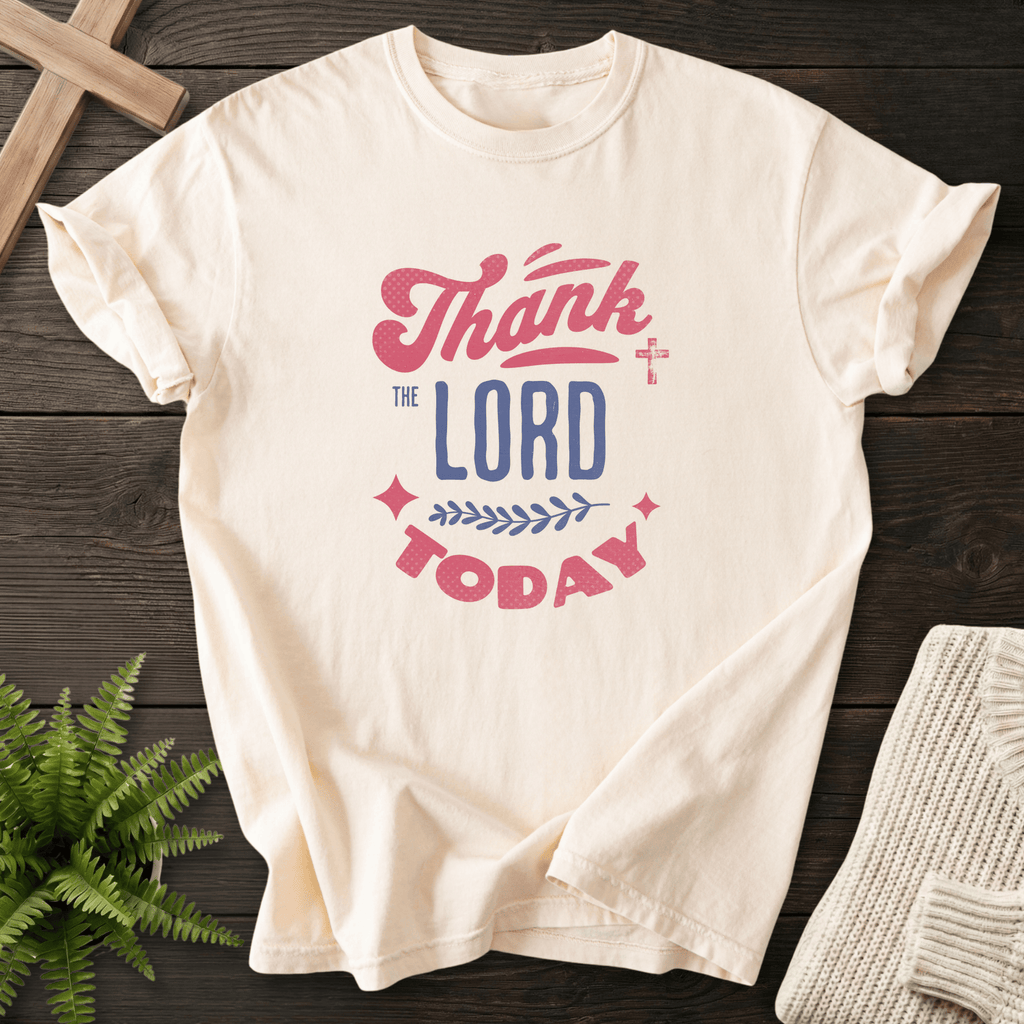 Ivory Bible verse tee with mixed retro fonts, a cross accent, and warm Thank the Lord Today lettering.