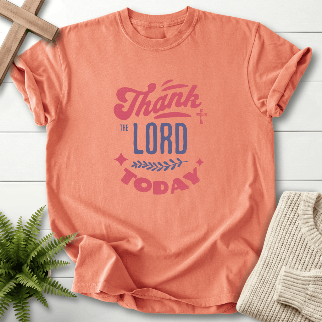 Terracotta Christian t-shirt for women with layered vintage Thank the Lord Today typography and a small cross detail.