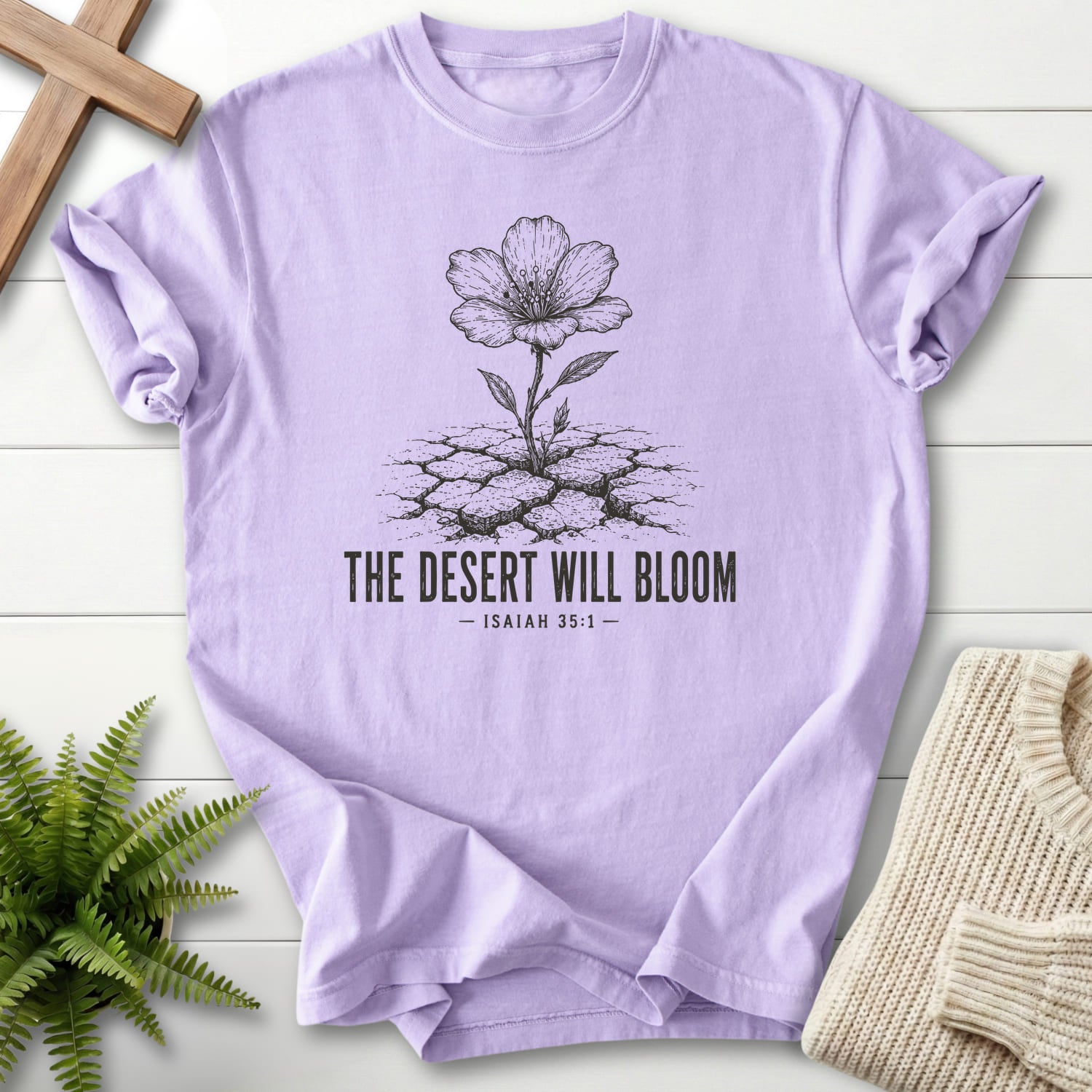Flat lay of an Orchid Christian graphic tee featuring flower artwork with "The Desert Will Bloom T-Shirt".