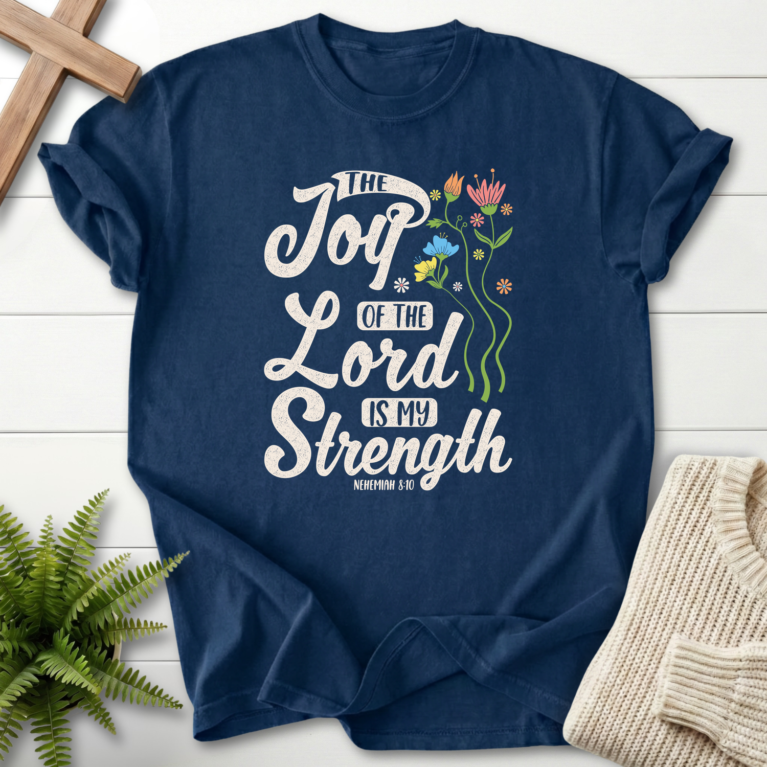 Navy Christian t-shirt for women with The Joy of the Lord Is My Strength in script and a floral illustration, inspired by Nehemiah 8:10.