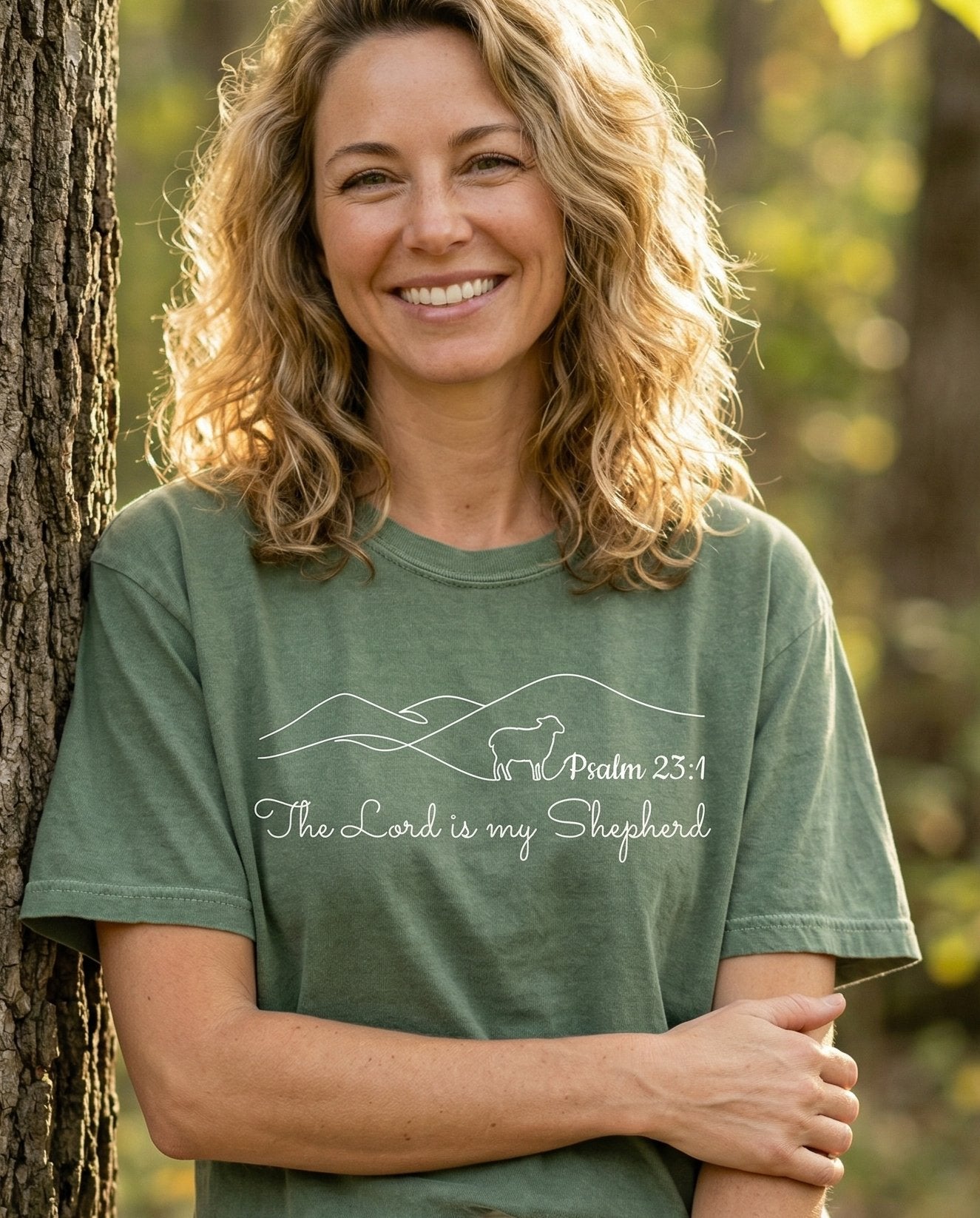 The Lord Is My Shepherd Minimalist – Moss women's Christian tee, lifestyle photo in nature trail – Minimalist single-line mountain landscape with a small lamb silhouette – Psalm 23:1 – She Wears Faith