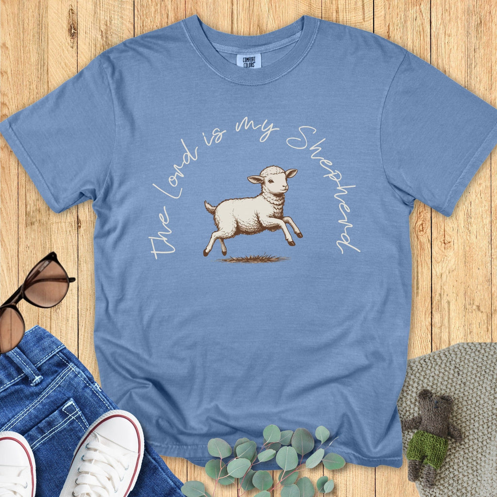 Flatlay of a Comfort Colors 1717 blue jean “The Lord Is My Shepherd” t-shirt styled with jeans and accessories. A gentle and meaningful women’s scripture tee that makes a thoughtful Christian mom gift idea.