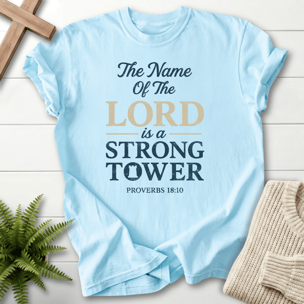 Chambray Christian t-shirt for women with bold layered text and The Name of the Lord Is a Strong Tower, inspired by Proverbs 18:10.