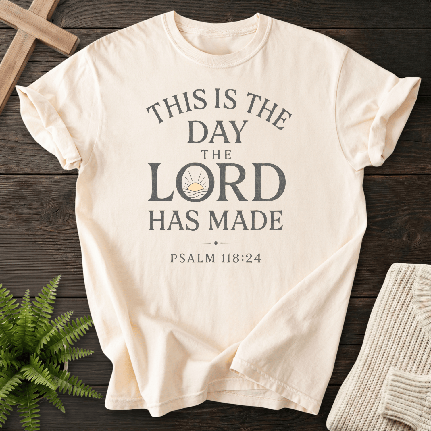 Ivory Christian t-shirt for women with clean bold stacked lettering and a sunrise icon, inspired by Psalm 118:24.