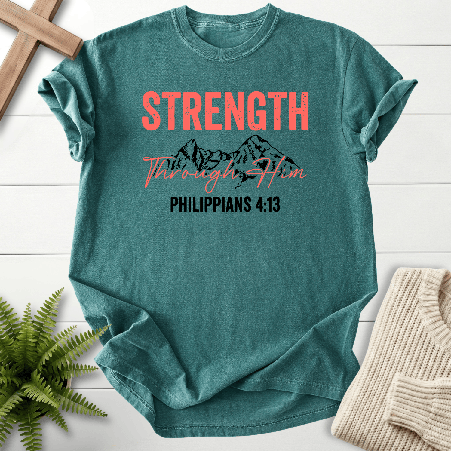 Blue Spruce Christian t-shirt for women with a mountain range sketch and Strength Through Him lettering, inspired by Philippians 4:13.