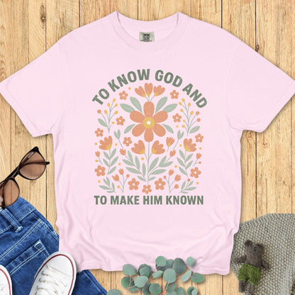 Flatlay of a Comfort Colors 1717 blossom “To Know God and To Make Him Known” t-shirt with hand-drawn floral illustration. A feminine women’s scripture tee — inspiring faith-based apparel for women and modern Christian shirt, perfect Christian mom gift idea.