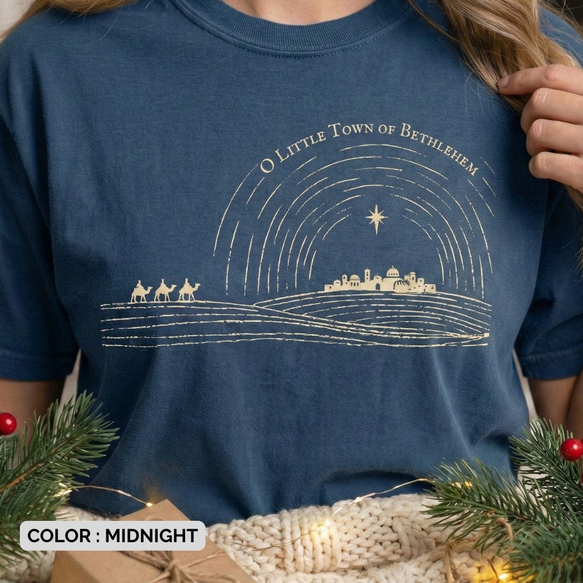 Comfort Colors 1717 midnight blue Christian women’s T-shirt displaying a hand-drawn nativity skyline under the Star of Bethlehem with the text “O Little Town of Bethlehem.” Scripture-rooted US faith wear for the Christmas season in a classic, vintage design.