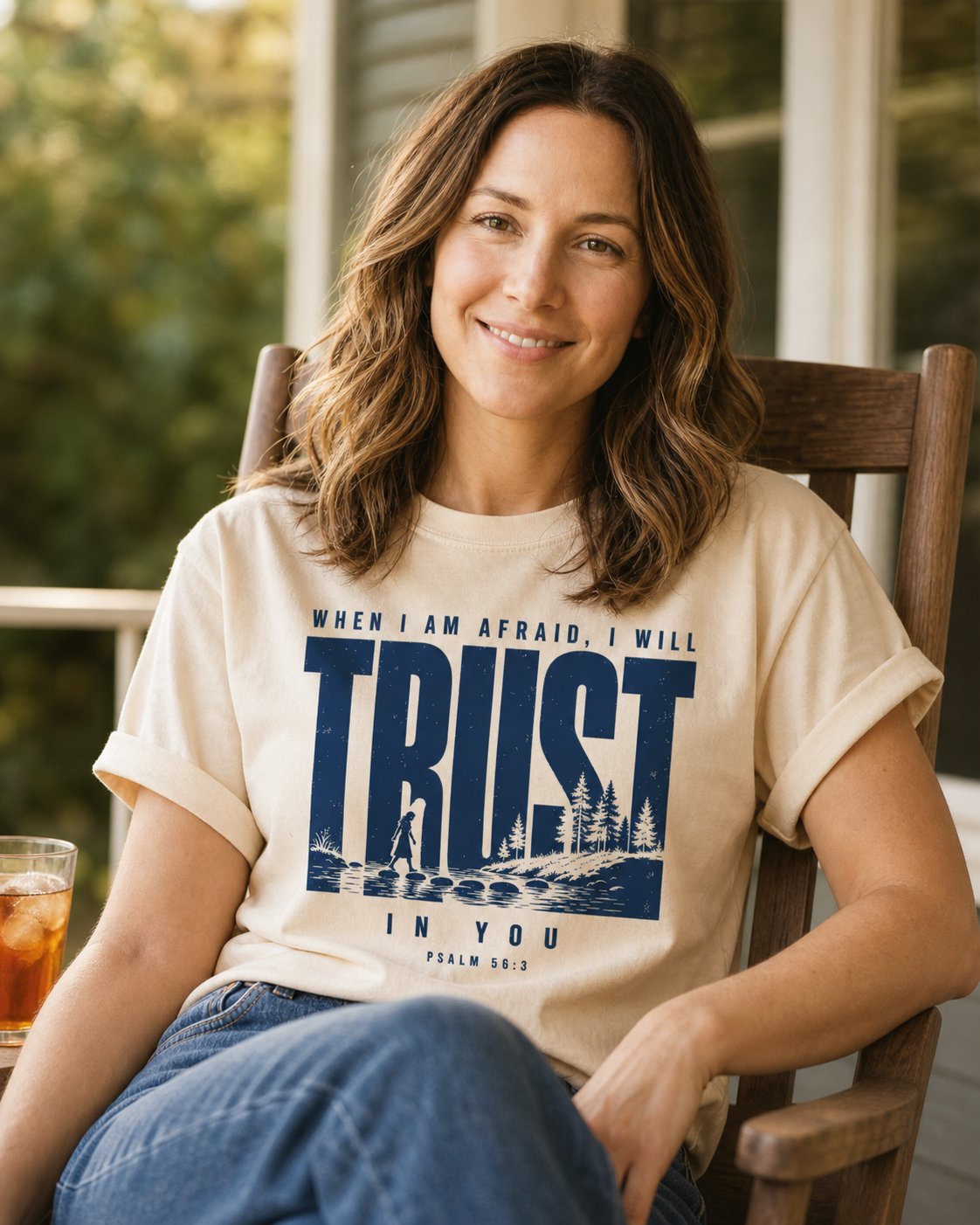 Trust When I am Afraid – Ivory women's Christian tee, lifestyle photo in sunny porch – Bold lettering over a woman crossing stepping stones at a river – Psalm 56:3 – She Wears Faith