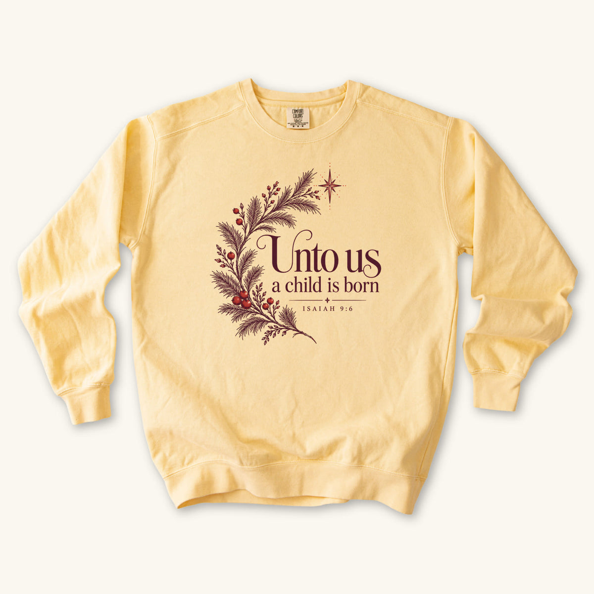 Butter Christian Christmas sweatshirt with Unto Us a Child Is Born lettering, evergreen branches, red berries, a star and Isaiah 9:6.