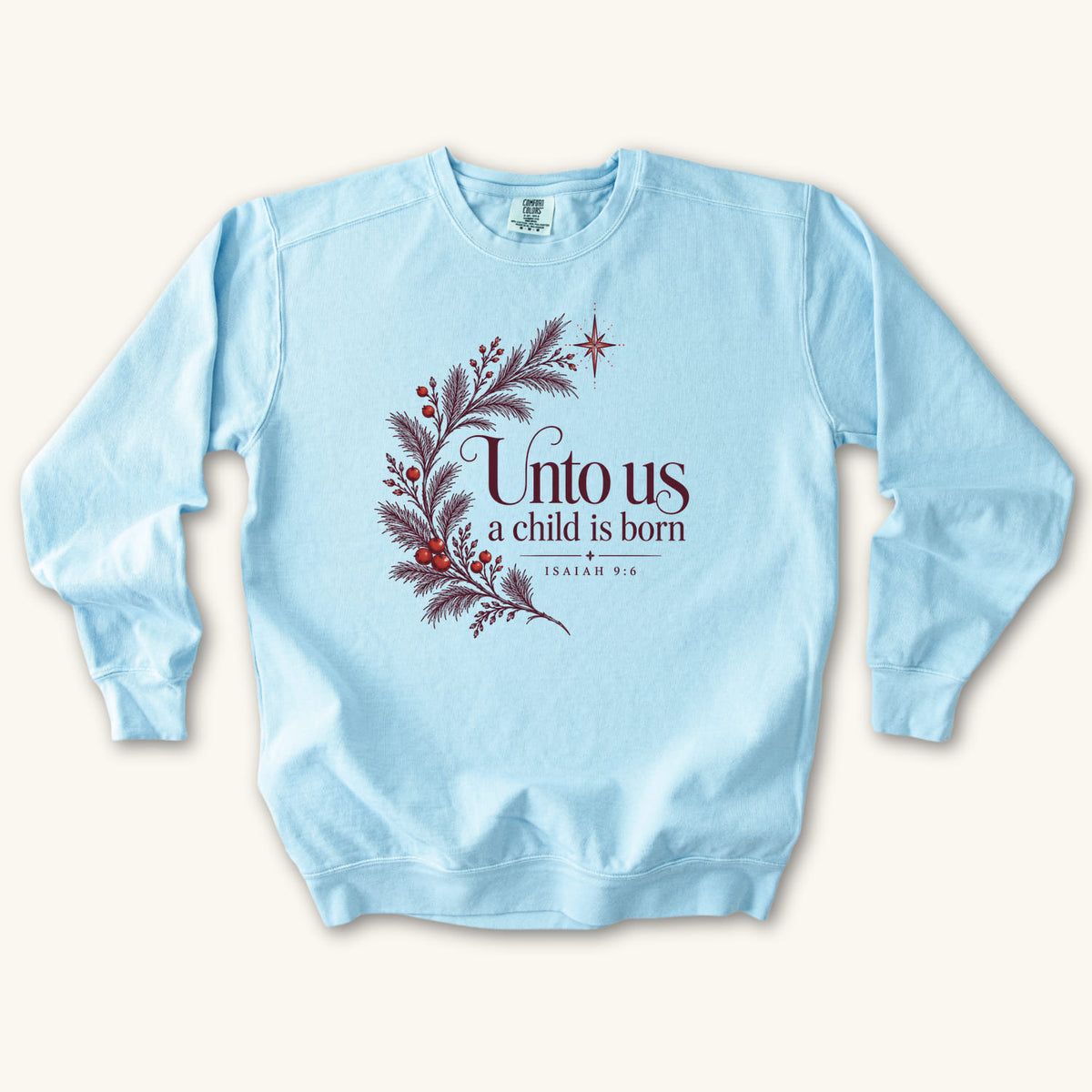 Chambray Christian Christmas sweatshirt with Unto Us a Child Is Born lettering, evergreen branches, red berries, a star and Isaiah 9:6.
