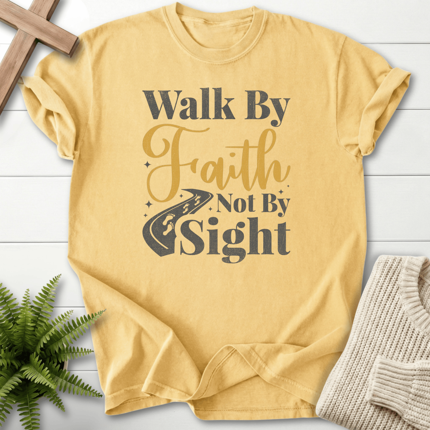 Butter Christian t-shirt for women with Walk By Faith Not By Sight text and a winding road graphic, inspired by 2 Corinthians 5:7.