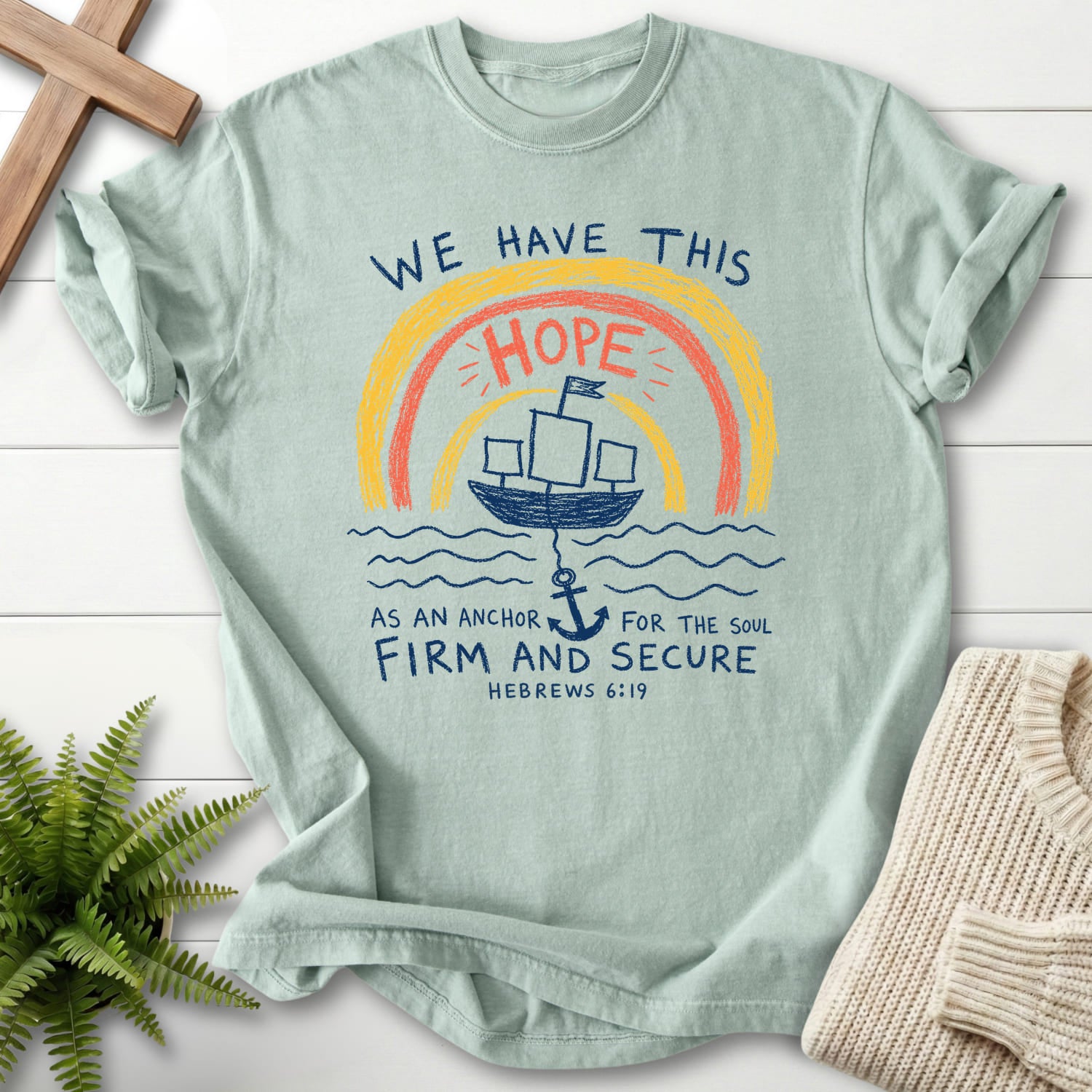 Flat lay of a Bay Christian shirt featuring "WE HAYE THIS T-Shirt" Hebrews 6:19.