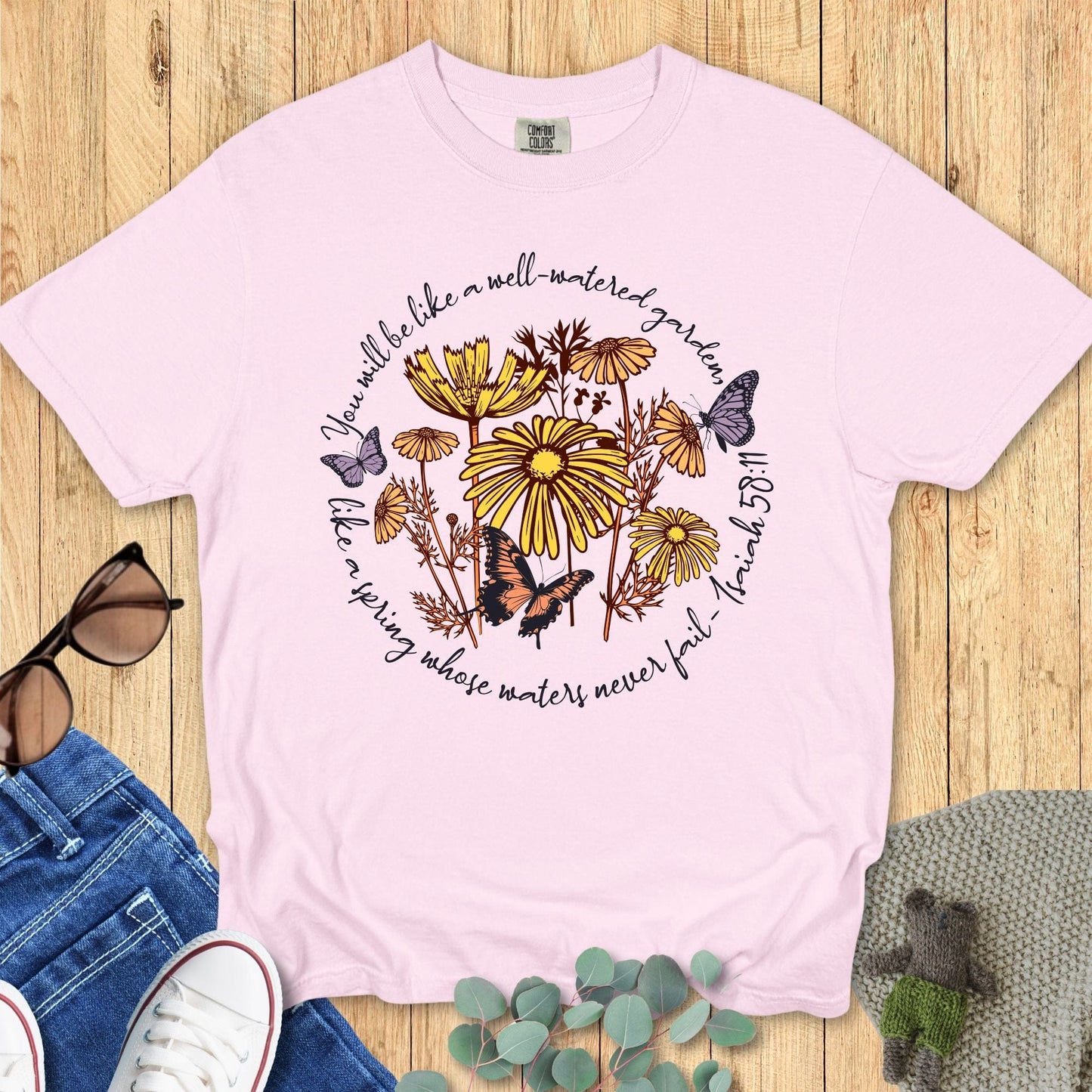 Christian Comfort Colors 1717 T-shirt in blossom pink with the same floral and butterfly scripture design, styled with casual flat lay props.