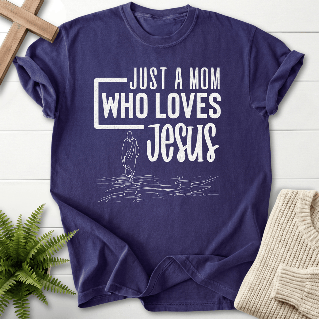 Grape women's Christian t-shirt with 'Just a Mom Who Loves Jesus' text and minimalist figure on water.
