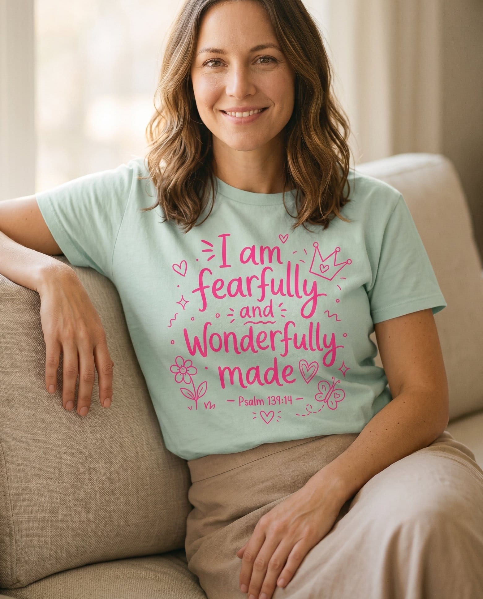 Fearfully and Wonderfully Made Psalm 139:14 – Bay women's Christian tee, lifestyle photo in cozy living room – Bright pink hand-lettering 'Fearfully and Wonderfully Made' surrounded – Psalm 139:14 – She Wears Faith