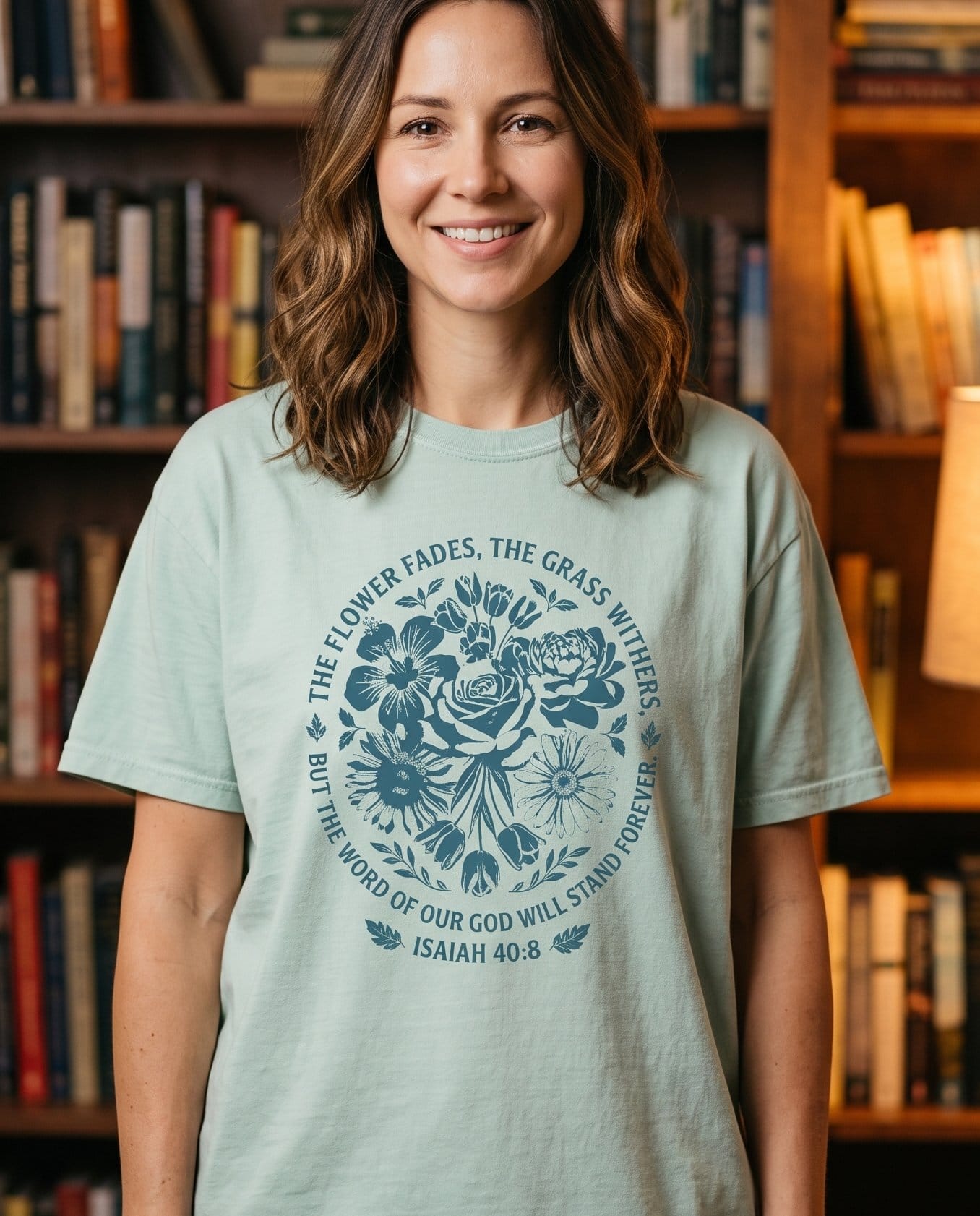 Word of God Stands Forever Isaiah 40:8 Floral – Bay women's Christian tee, lifestyle photo in cozy reading nook – Dense deep-blue woodblock-style bouquet of roses – Isaiah 40:8 – She Wears Faith