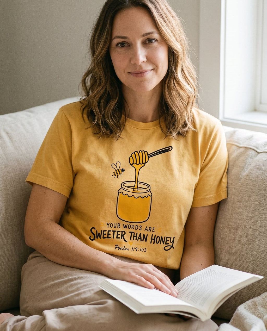 Words Sweeter Than Honey – Mustard women's Christian tee, lifestyle photo in cozy living room – Hand-drawn honey jar with a dripping dipper and a bee – Psalm 119:103 – She Wears Faith