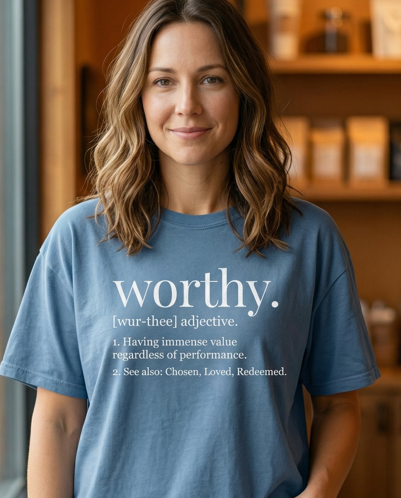 Worthy Definition – Blue Jean women's Christian tee, lifestyle photo in cozy café – Dictionary definition style layout: 'worthy – She Wears Faith