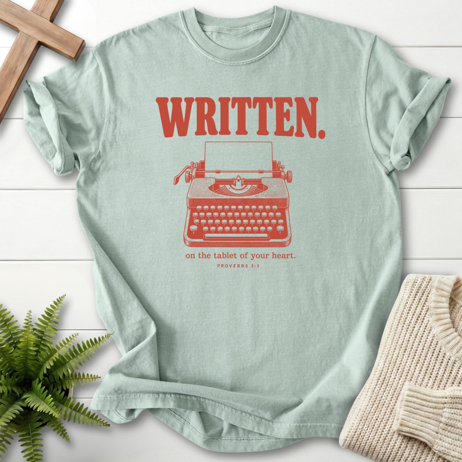 Flat lay of a Bay Scripture shirt featuring "Written on the Tablet of Your T-Shirt" Proverbs 3:3.