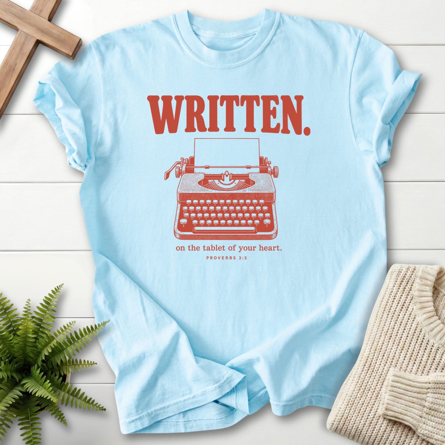 Flatlay of a Chambray Bible verse tee with "Written on the Tablet of Your T-Shirt" Proverbs 3:3.