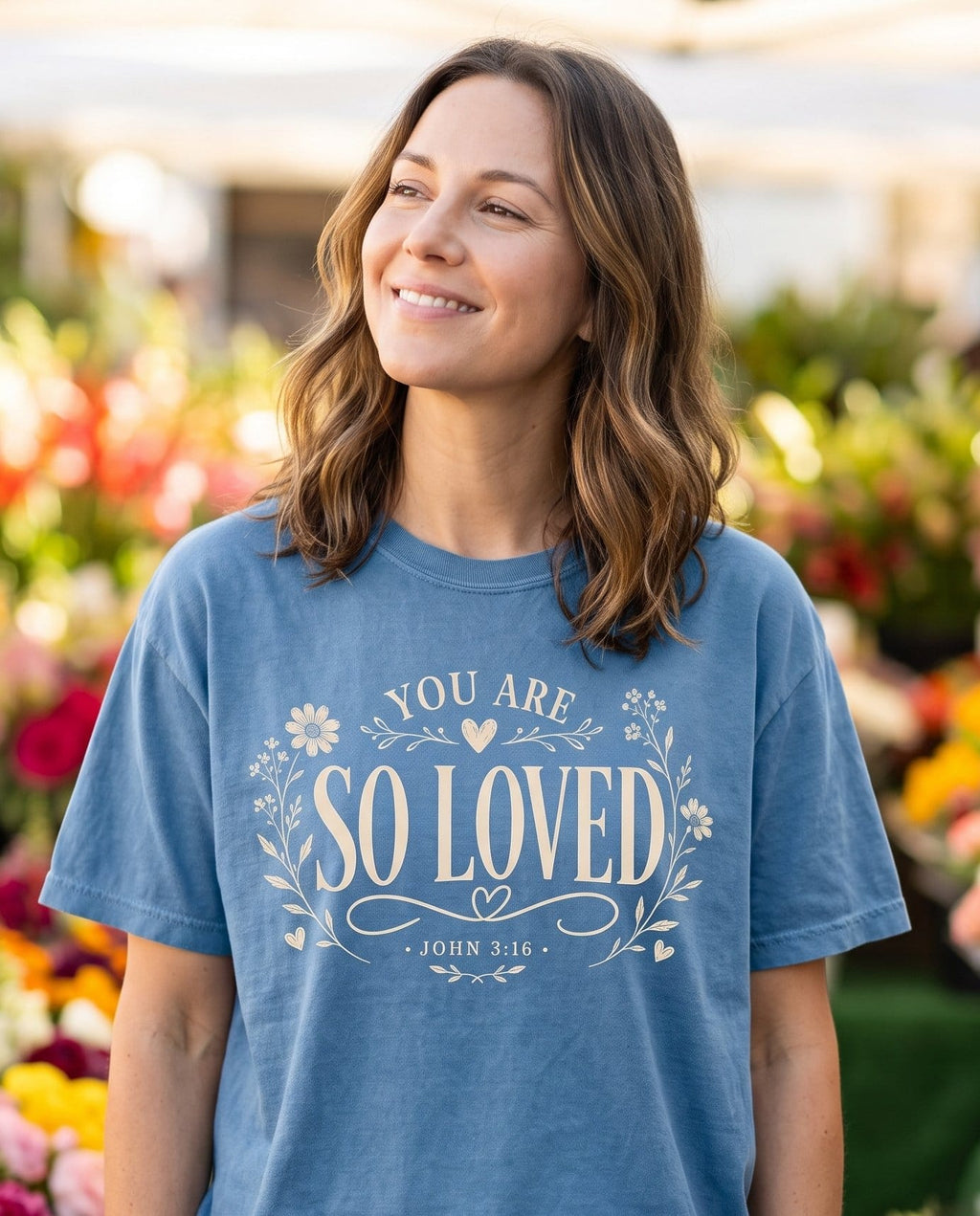 You Are So Loved – Blue Jean women's Christian tee, lifestyle photo in farmers market – Elegant floral wreath lettering "You Are So Loved" with hand-drawn flo – John 3:16 – She Wears Faith