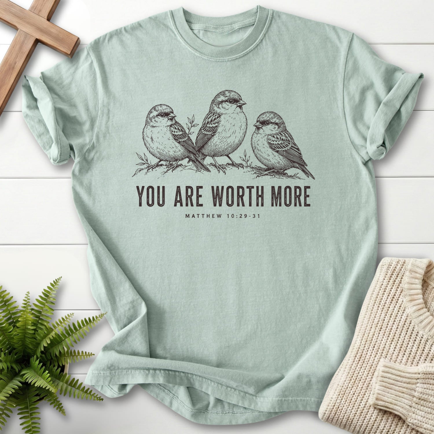 Flat lay of a Bay faith-based tee featuring "You Are Worth More Sparrows T-Shirt" design.