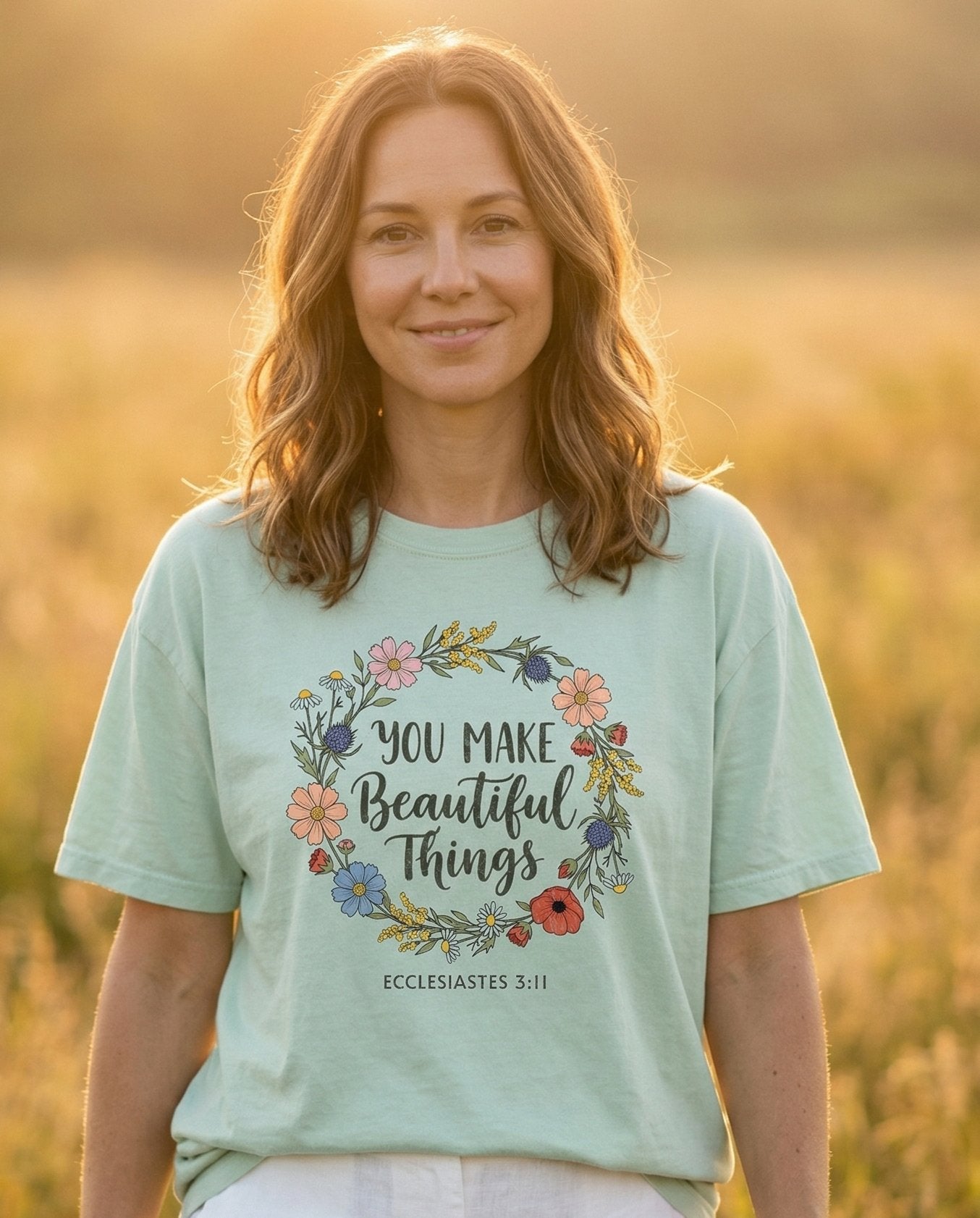 You Make Beautiful Things – Bay women's Christian tee, lifestyle photo in wildflower meadow at sunrise – Colorful wildflower wreath with poppies – Ecclesiastes 3:11 – She Wears Faith